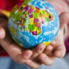child holding globe, raising globally conscious children
